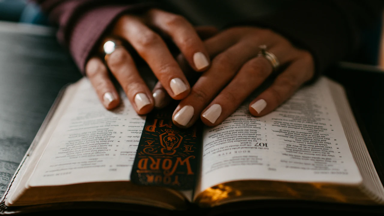 Hands resting on an open Bible